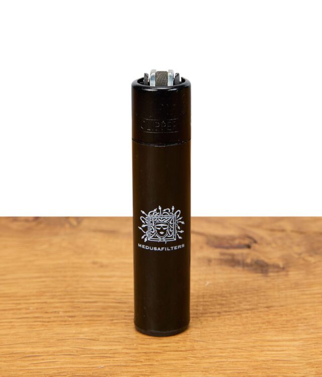 Schwarzes Clipper Feuerzeug mit Medusafilters-Logo auf einer Holzoberfläche.