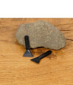 Zwei schwarze Kunststoff-Schaber auf Steinunterlage, ideal zum Auskratzen von Grinder-Resten