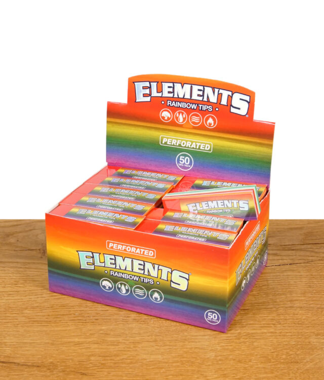 Eine geöffnete Box mit mehreren bunten Verpackungen von Elements Rainbow Tips, auf einem Holztisch stehend. Das Elements-Logo ist gut sichtbar.