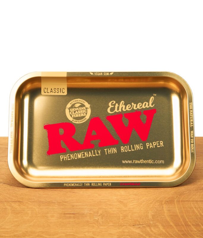 RAW Ethereal Small Rolling Tray in Metall-Goldoptik mit großem RAW-Logo und Classic-Label, flach auf Holz liegend, Zubehör für Rolling Papers.