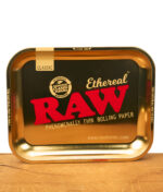 RAW Ethereal Large Rolling Tray in Metall-Goldoptik mit großem RAW-Logo und Classic-Label, flach auf Holz liegend, Zubehör für Rolling Papers.
