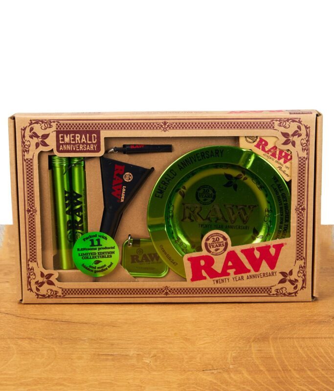 RAW Emerald Anniversary Giftset Verpackung mit grünem Aschenbecher, Tube, Schlüsselanhänger und Zubehör in einer limitierten Jubiläumsbox, auf Holzoberfläche.