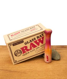 RAW Glass Bat Premium Cone Holder, handgefertigter Glas-Halter in Rot-Orange, neben der Originalverpackung auf Holz.