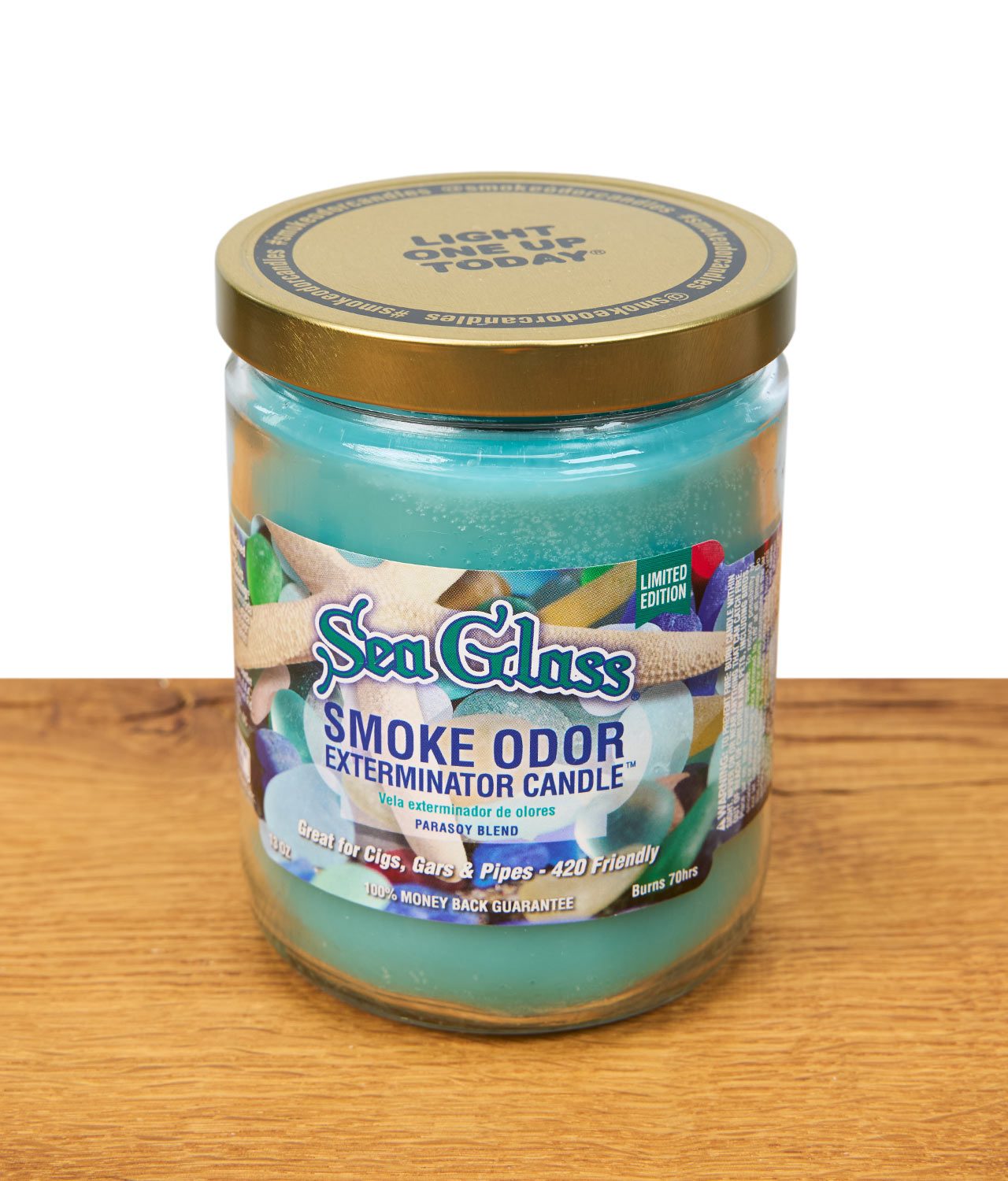 smoke-odor-sea-glass-jpg Die türkise Duftkerze "Sea Glass" mit buntem Aufdruck steht auf Holz präsentiert