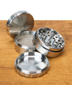 EHLE vierteiliger Edelstahl Grinder offen, alle Kammern und Mahlzähne auf Holztisch sichtbar.