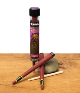 G-Rollz Blunt Cones Purple Haze mit charakteristischer Tube, zwei vorgerollte King Size Blunts und Stopfhilfe auf Holztisch.