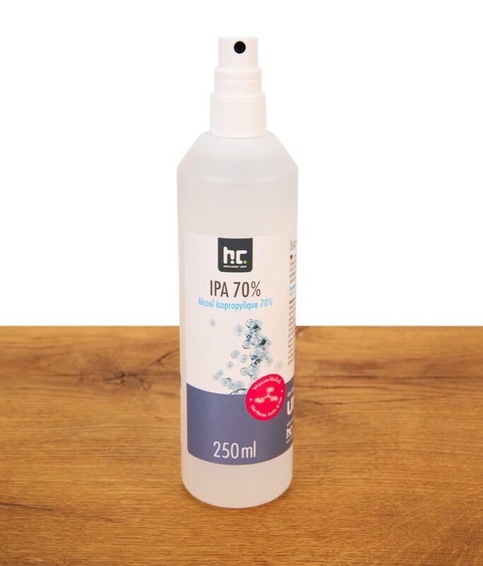Sprühflasche für 70% Isopropanol in weiß einzeln stehend auf Holz