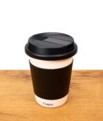 Puffco Cupsy Kaffeebecher Bong in schwarz weiß auf Holz stehend