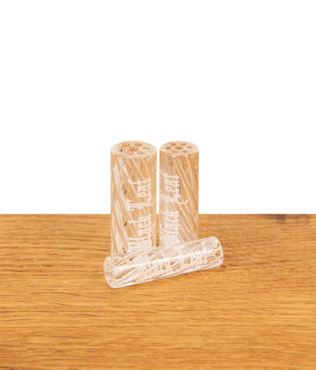 Zwei größere Black Leaf Glasfilter mit Streifenmuster stehen nebeneinander auf einer Holzoberfläche vor weißem Hintergrund, mit einem kleineren Filter schräg davor liegend.