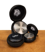 Arrangement verschiedener Steely Dan Grinder liegend in ihren geöffneten und geschlossenen Transporttaschen