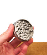 Nahaufnahme der scharfen Mahlzähne im Inneren des Steely Dan Edelstahl Grinders in einer Hand
