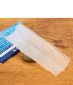 Ein hauchdünnes, fast transparentes Elements Phantom Rolling Paper mit Waben-Wasserzeichen liegt ausgebreitet auf einem Stein.