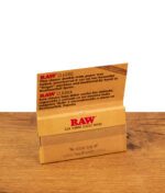 Geöffnetes Heftchen der RAW Classic Double Wide Papers aus ungebleichten Pflanzenfasern mit natürlicher Gummierung auf Holzgrund.