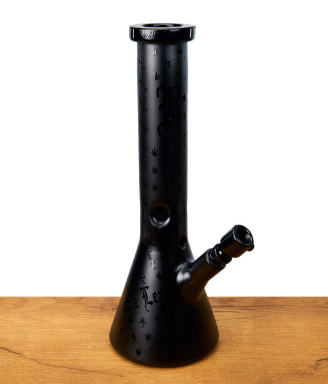 Schwarze Black Leaf Beakerbong mit eingravierten Hanfblättern und Schriftzug, seitliche Ansicht auf Holztisch.