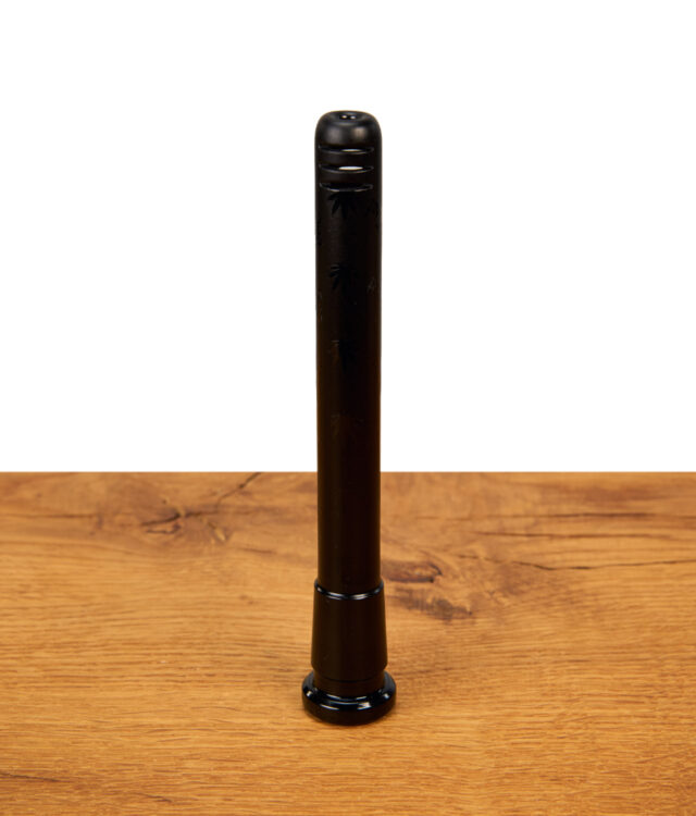 Schwarzer Black Leaf Chillum aus Glas mit Cannabisblatt-Gravur und geriffeltem Mundstückende steht aufrecht auf einer Holzoberfläche vor weißem Hintergrund.