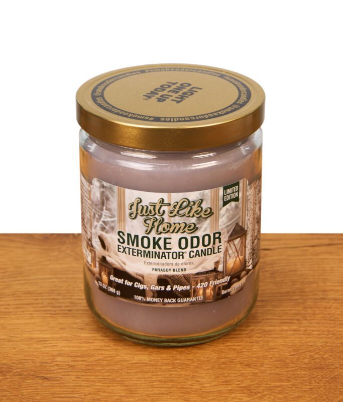 Smoke Odor Exterminator Candle Just Like Home in der 368g Glasdose mit goldenem Metalldeckel auf Holzoberfläche.