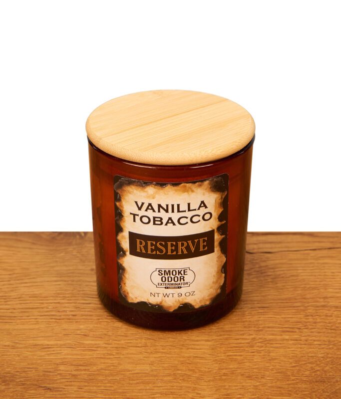 Smoke Odor Reserve Vanilla Tobacco Anti-Tabak-Kerze im braunen Glas mit Holzdeckel auf einer Echtholz-Unterlage.