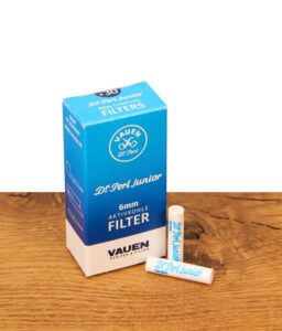Packung Vauen Dr. Perl junior 6mm Aktivkohlefilter mit zwei lose liegenden Filtern auf einer Holzoberfläche.