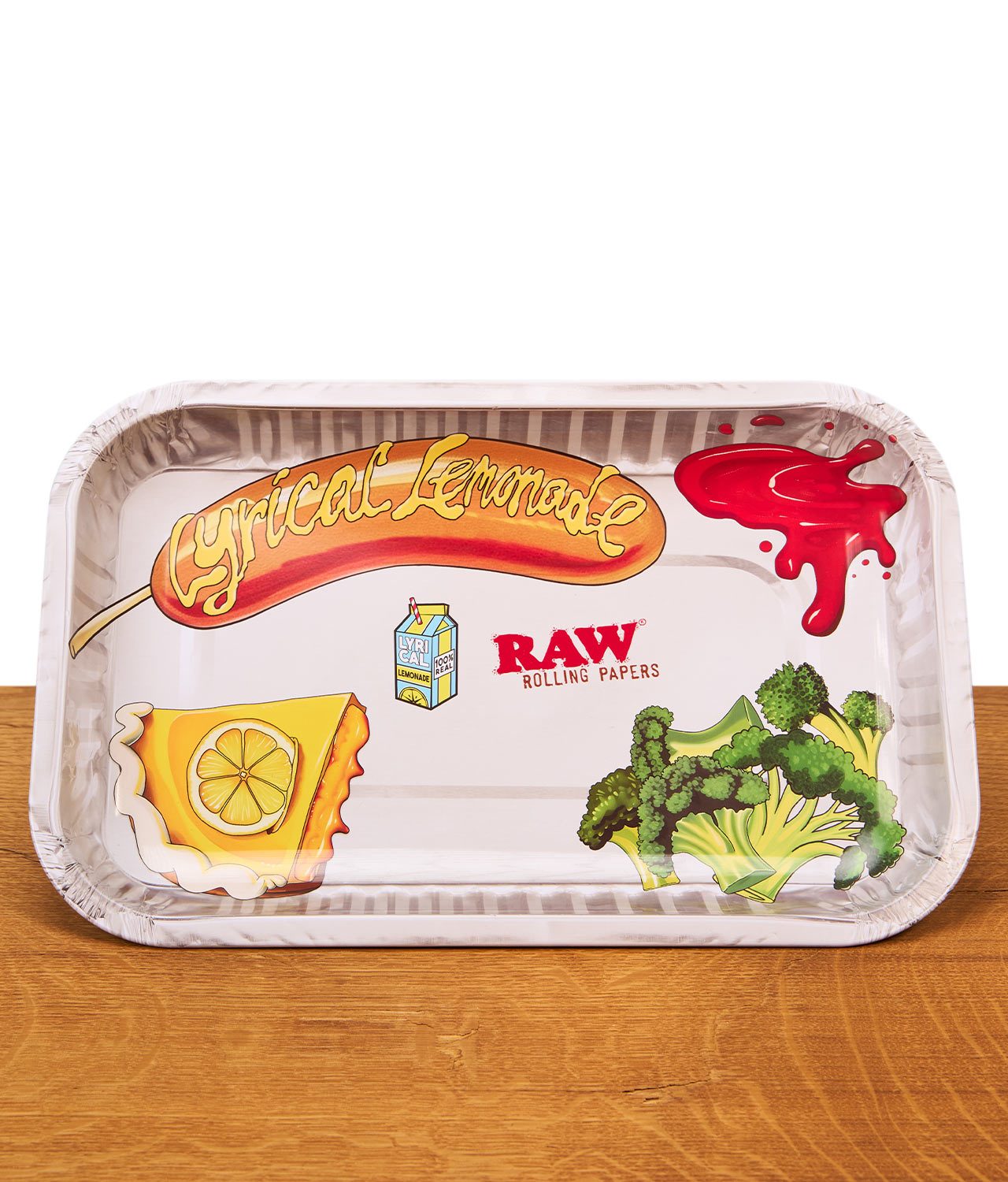 raw-lyrical-lemonade-lunch-rolling-tray-small-jpg Kleines RAW x Lyrical Lemonade Lunch Rolling Tray aus Metall mit bunten Food-Prints von Hotdog, Brokkoli und Zitronenkuchen auf hellem Grund.
