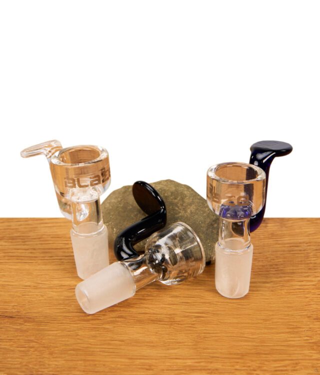 Drei Blaze Glass Bongköpfe in den Varianten Klar, Blau und Schwarz mit Griff und NS 14 Schliff im Gruppen-Lifestyle-Arrangement.