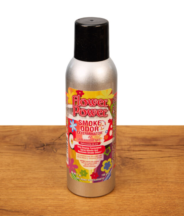 Smoke Odor Exterminator Lufterfrischer Spray in der Duftrichtung Flower Power in einer silbernen 7oz Metalldose auf Holzgrund.