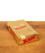 Eine Packung der phänomenal dünnen RAW Ethereal Papers im 1 1/4 Format, präsentiert in einer Hand vor weißem Hintergrund.