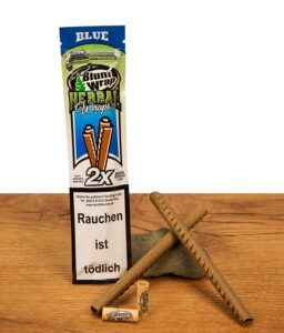 Blaues Blunt Wrap Herbal Wraps Blue 2er Pack neben zwei gekreuzten Kräuter-Hüllen und Holz-Filtern auf rustikalem Holz.