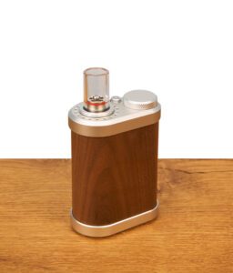 Tinymight 2 Vaporizer im Standard-Setup auf Holz. Das Gerät kombiniert einen massiven Holzkorpus mit einem kurzen Borosilikatglas-Mundstück.