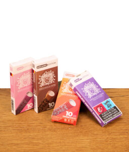 Vier 10er Packungen Medusa Aktivkohlefilter in den Editionen Rosé, Organic, Sunset und Violet auf einem Holztisch.