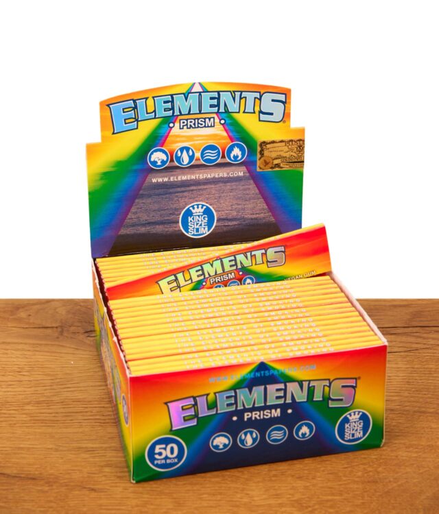 Geöffnete Elements Prism Papers 50er Box im farbenfrohen Regenbogen-Design auf einer Holzoberfläche.