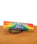 Frontalansicht der Elements Prism Papers King Size Slim Packung mit Fokus auf die vier Elemente-Symbole (Erde, Wasser, Wind, Feuer)
