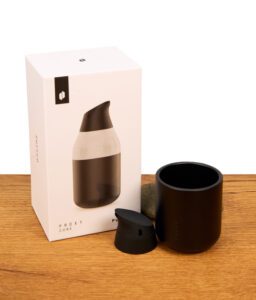 Puffco Proxy Core Accessory Kit in Onyx neben der weißen Originalverpackung; zu sehen sind der schwarze Proxy Core Cup und das passende Proxy Core Mundstück auf Holzgrund.