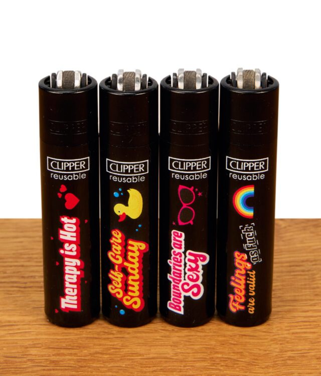 Set aus vier nachfüllbaren Clipper Feuerzeugen der Mental Health Kollektion auf Holz, mit Sprüchen: "Therapy is Hot", "Self-Care Sunday", "Boundaries are Sexy", "Feelings are Valid".