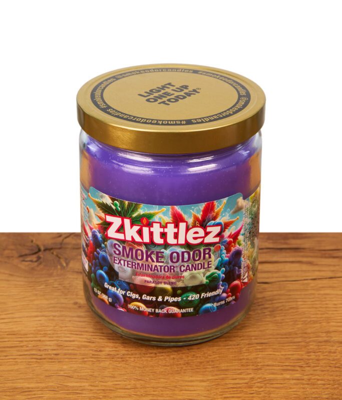 Geschlossene Smoke Odor Exterminator Duftkerze "Zkittlez" im 13oz Glas mit goldenem Metalldeckel und farbenfrohem, psychedelischem Etikett auf Holzgrund.