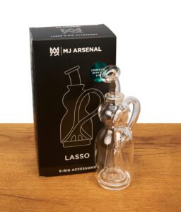 MJ Arsenal Lasso E-Rig Accessory aus Glas stehend neben der minimalistischen schwarzen Produktverpackung.