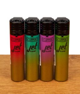 4er-Serie Clipper Feuerzeuge Jet Flame Metallic Gradient. Vier Sturmfeuerzeuge in Rot, Türkis, Pink und Grün mit schwarzem Kopf auf Holz.