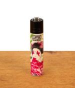 Clipper Feuerzeug FFX Mittenimwald Motoerhead auf einem Holztisch. Nachfüllbares Nylon-Gehäuse bedruckt mit Geisha-Motiv und rotem Fächer.