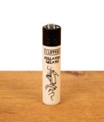 Clipper Feuerzeug Adult #4 Fellatio Gelato. Mehrweg-Gasfeuerzeug mit schwarzer Kappe und Erotik-Print auf Holztisch.
