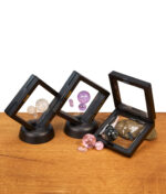 Übersicht verschiedener Calvo Glass Marble Sets. Geöffnete und stehende schwarze Rahmen mit bunten Glas-Terp-Pearls auf Holztisch.