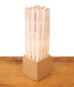Dicht gestapelte weiße Cones Black King Size Prerolled mit Papp-Filtertip im Pappeinsatz auf Holztisch.