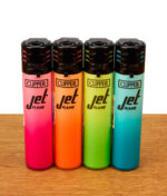 Die vollständige Kollektion der Clipper Jet Flame Metallic Gradient #10 Feuerzeuge in den Farben Pink, Orange, Grün und Blau, präsentiert auf einer Holzoberfläche.
