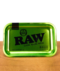 RAW Emerald Anniversary Rolling Tray in leuchtendem Grün mit schwarzem RAW-Logo und Jubiläumsaufdruck „20 Rawsome Years“ auf Holzuntergrund.
