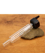 Der XMAX V3 Pro Glasbubbler (auch passend als XMAX V4 Pro Glasbubbler Zubehör) ist fest mit seiner schwarzen Adapterbasis verbunden und liegt horizontal auf einem Dekostein.