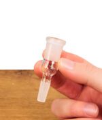 Ein einzelner Bongadapter NS10 auf NS14 aus Borosilikatglas wird von Fingern gehalten, um den präzisen Übergang vom kleineren Kernschliff zur größeren Schliffhülse zu zeigen.