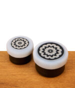 Zwei schwarze Kräutermühlen in unterschiedlichen Durchmessern, beide perfekt ausgerüstet mit dem grauen Mill Grip für Flower Mill Grinder für besseren Halt und zusätzlichen Schutz.