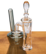 Nahaufnahme des Komplettsets des MJA Hourglass Bangers mit Banger im Rig, Terp Pearls und montierte Carb Cap auf Holz präsetiert.