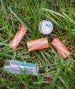RipTip Honeysuckle Glasfilter Outdoor-Lifestyle – orange-rote Filter mit Tubus im Gras, entspannte Headshop-Atmosphäre