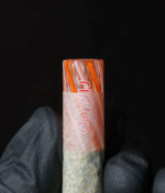 RipTip Honeysuckle Glasfilter auf Joint gesteckt – Seitenansicht zeigt orangen Glasfilter als Mundstück am Tütchen