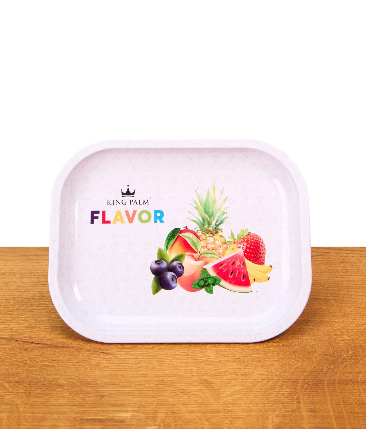 king-palm-rolling-tray-flavor-mini-jpg King Palm Rolling Tray Flavor Mini aus Metall auf einem Holztisch. Weißes Drehtablett mit erhöhtem Rand, bunter Fruchtgrafik und Logo.