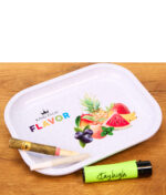 Weißes King Palm Rolling Tray Flavor Mini mit Früchtemotiv auf einem Holztisch, bestückt mit Pre-Roll Blunt, Joint und grünem Feuerzeug.